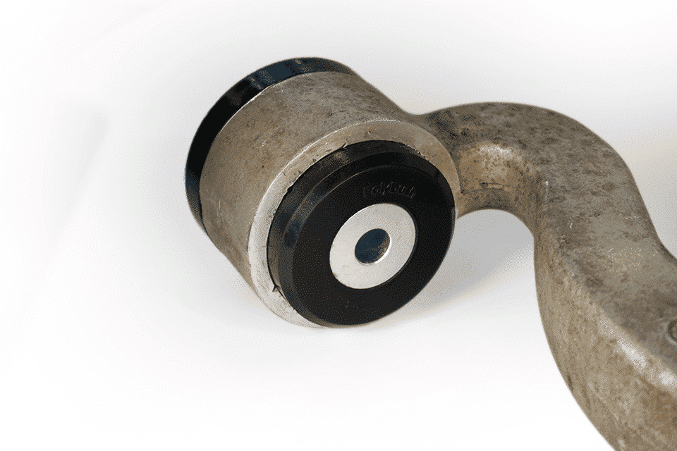 Close-up of a metallic crankshaft mounted on a white background, highlighting its polished surfaces and central bearing with notations.
